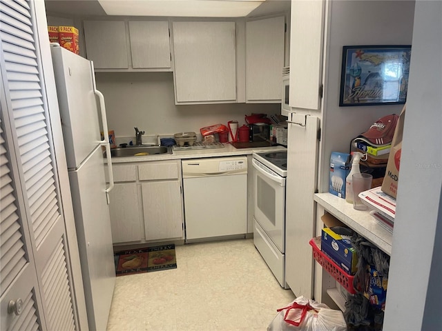 kitchen featuring white appliances, gray cabinets, and sink