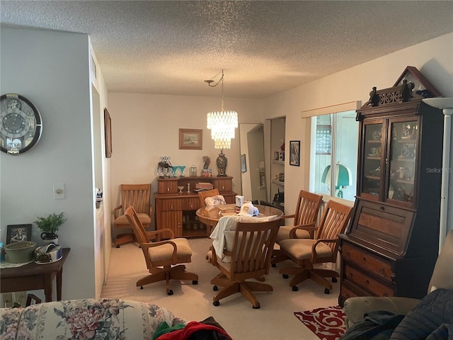 dining room featuring a chandelier, carpet floors, and a textured ceiling