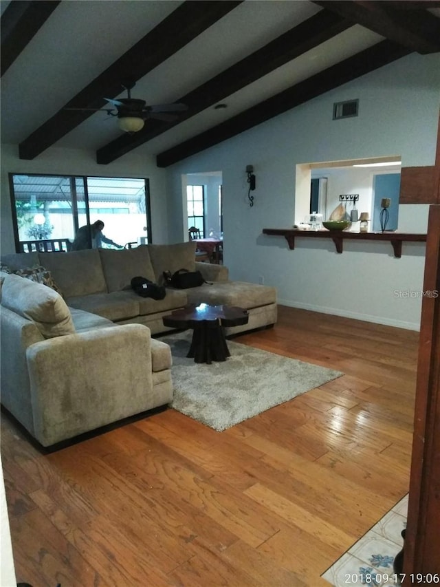 living room featuring lofted ceiling with beams, ceiling fan, and wood-type flooring