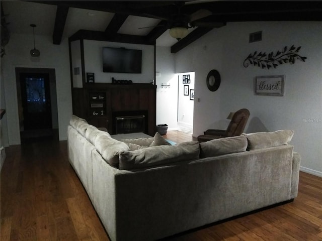 living room with hardwood / wood-style flooring, ceiling fan, and vaulted ceiling with beams