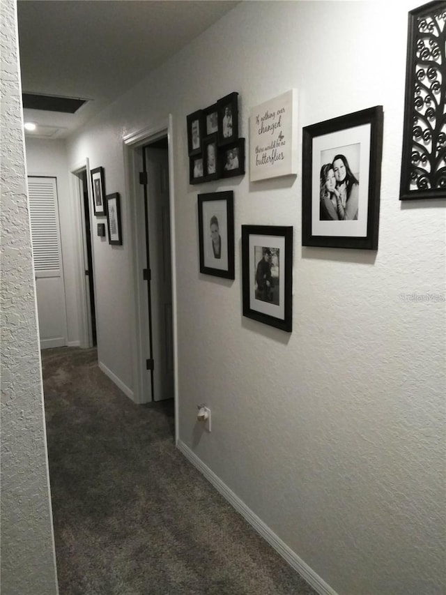 hallway with dark colored carpet