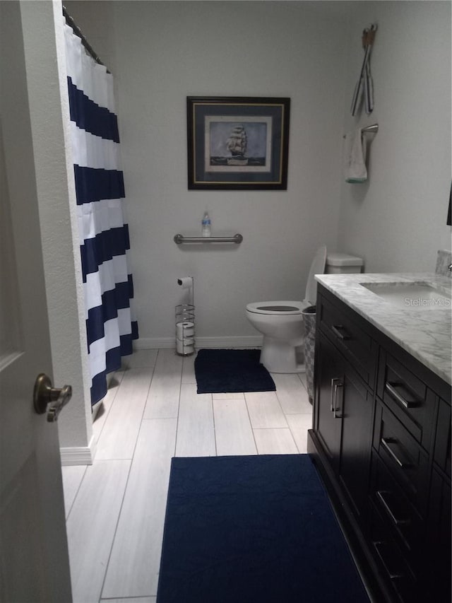 bathroom with toilet, vanity, and tile patterned floors