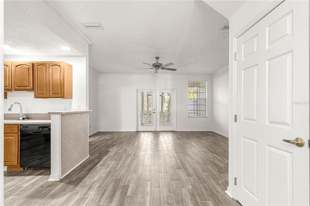 unfurnished living room with ceiling fan, sink, a textured ceiling, and hardwood / wood-style flooring