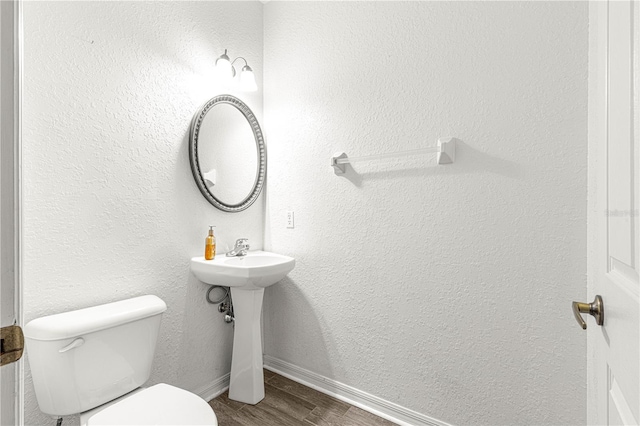 bathroom with toilet and hardwood / wood-style flooring