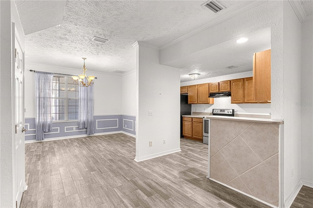 kitchen with stainless steel range with electric stovetop, crown molding, exhaust hood, decorative light fixtures, and a chandelier