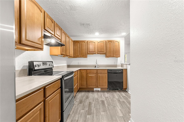 kitchen featuring sink, black dishwasher, a textured ceiling, stainless steel range with electric cooktop, and light wood-type flooring