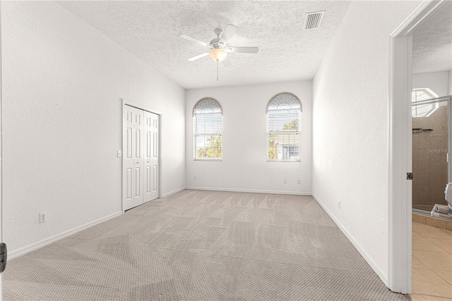 unfurnished room featuring ceiling fan and light carpet