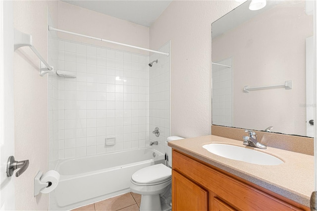 full bathroom with tiled shower / bath, tile patterned flooring, vanity, and toilet