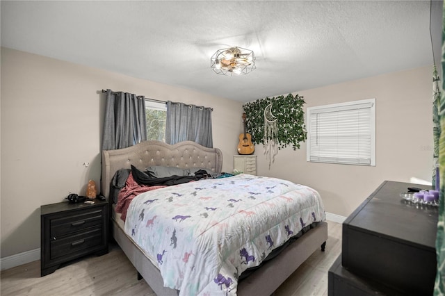 bedroom with light hardwood / wood-style flooring and a textured ceiling