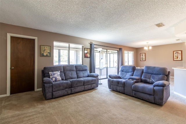 living room featuring light carpet, a textured ceiling, and an inviting chandelier