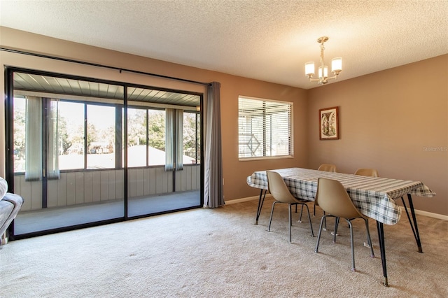 dining room featuring light carpet, a textured ceiling, and a notable chandelier