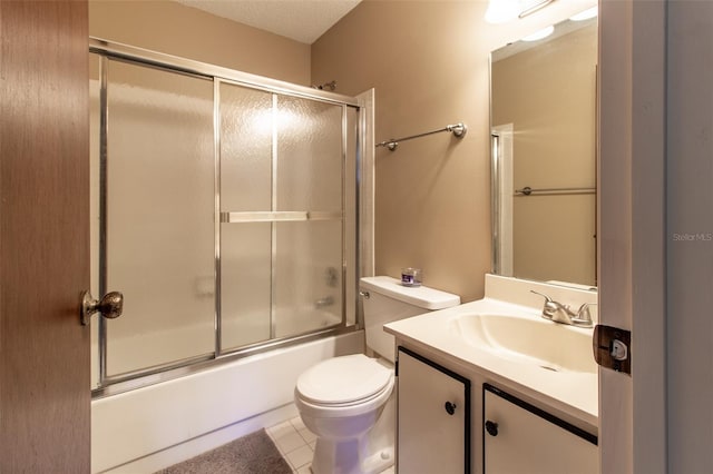 full bathroom with tile patterned flooring, toilet, combined bath / shower with glass door, and vanity