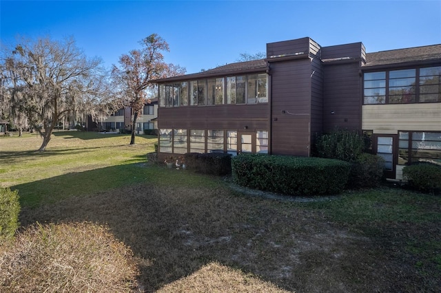 view of home's exterior featuring a sunroom and a yard