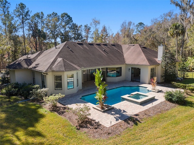 view of pool featuring an in ground hot tub, a lawn, and a patio