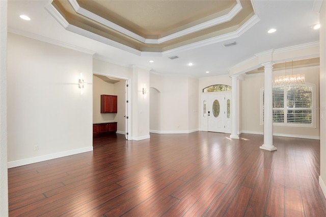 unfurnished living room featuring an inviting chandelier, ornamental molding, ornate columns, and a tray ceiling