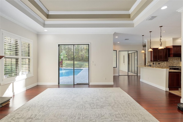 living room featuring dark wood-type flooring, a raised ceiling, and crown molding