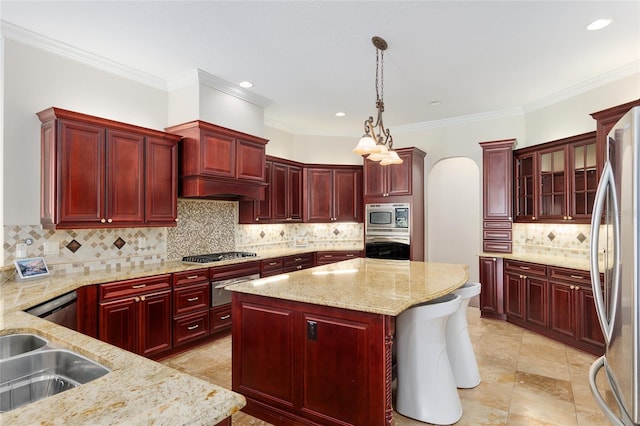 kitchen featuring light stone countertops, appliances with stainless steel finishes, a center island, and decorative light fixtures