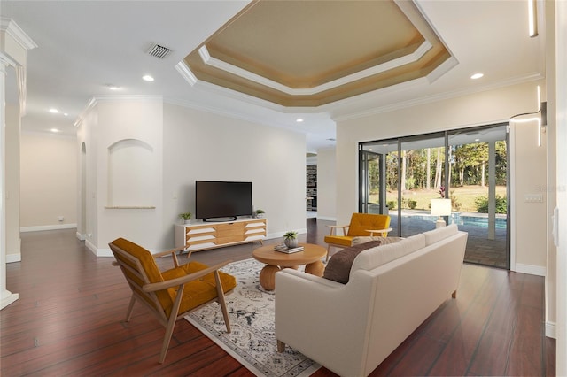 living room featuring ornamental molding, dark hardwood / wood-style floors, and a tray ceiling