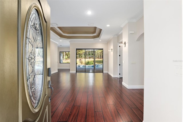 interior space with ornamental molding, dark hardwood / wood-style flooring, and a tray ceiling