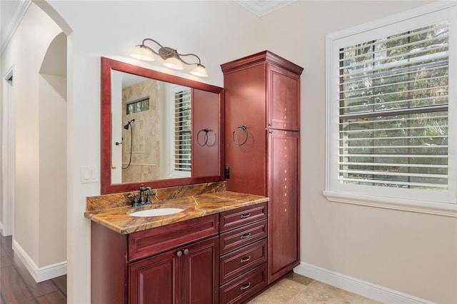 bathroom with a shower, crown molding, and vanity