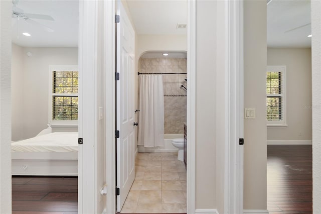 hall featuring plenty of natural light and light tile patterned flooring