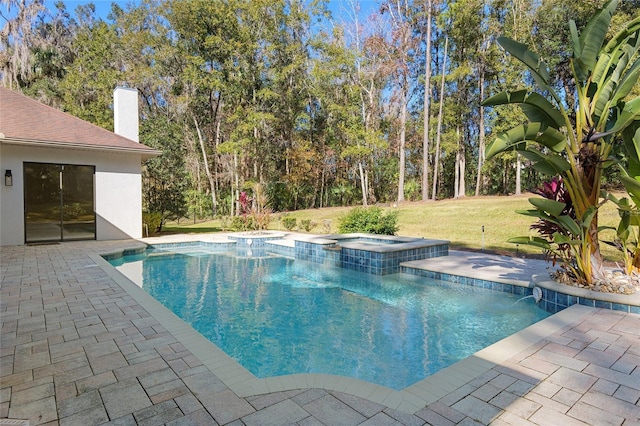 view of swimming pool featuring an in ground hot tub, a yard, and a patio