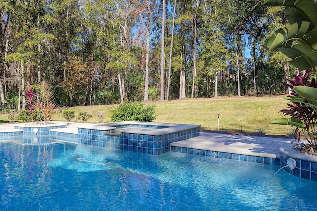 view of pool with an in ground hot tub and a yard