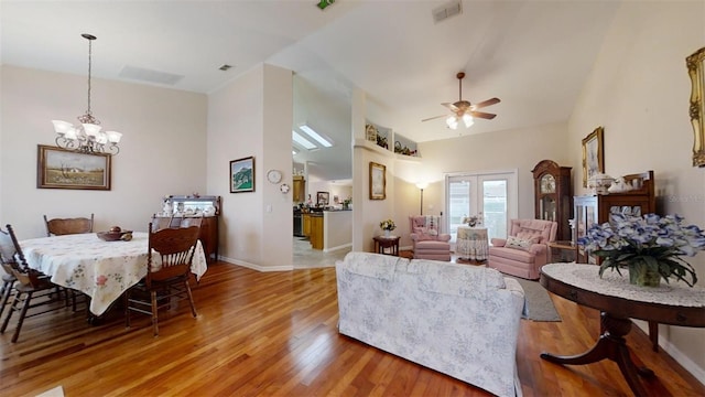 living room featuring ceiling fan with notable chandelier, french doors, and hardwood / wood-style floors