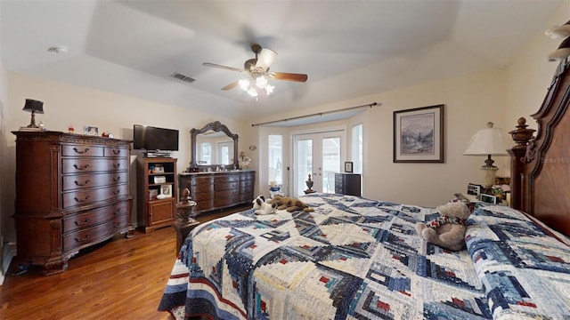 bedroom featuring a raised ceiling, french doors, ceiling fan, and light hardwood / wood-style floors