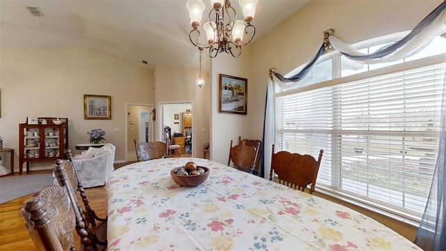 dining area featuring lofted ceiling and a chandelier