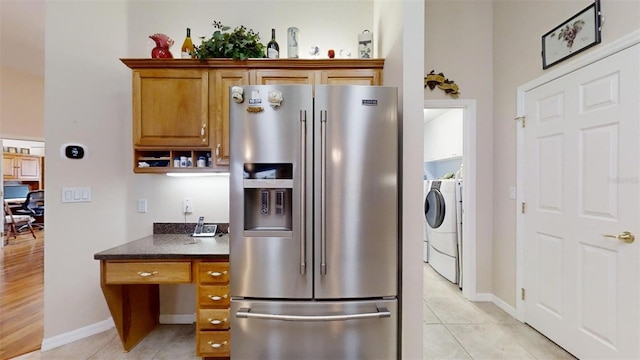 kitchen with high quality fridge, light tile patterned floors, and independent washer and dryer