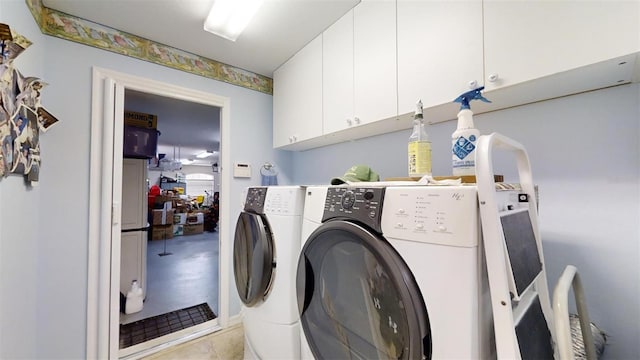 laundry room featuring washer and dryer, light tile patterned floors, and cabinets