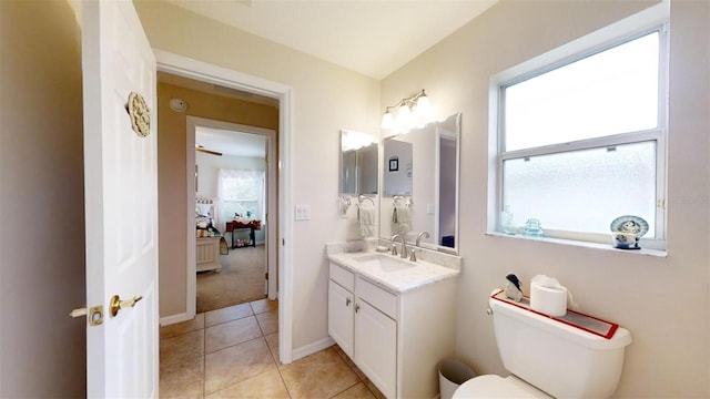 bathroom featuring toilet, vanity, tile patterned flooring, and a wealth of natural light