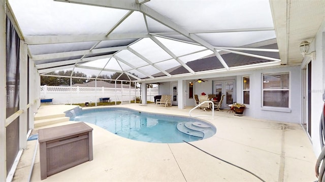 view of swimming pool featuring french doors, glass enclosure, and a patio