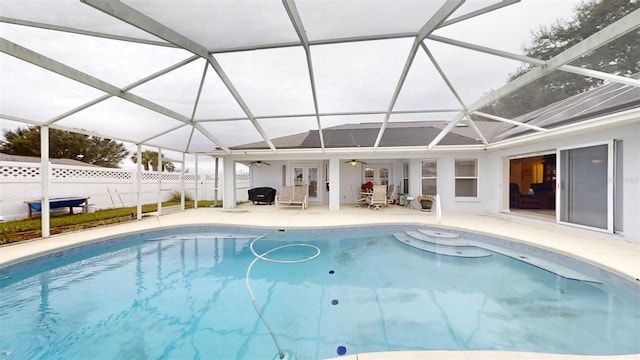 view of swimming pool featuring ceiling fan, french doors, glass enclosure, and a patio area