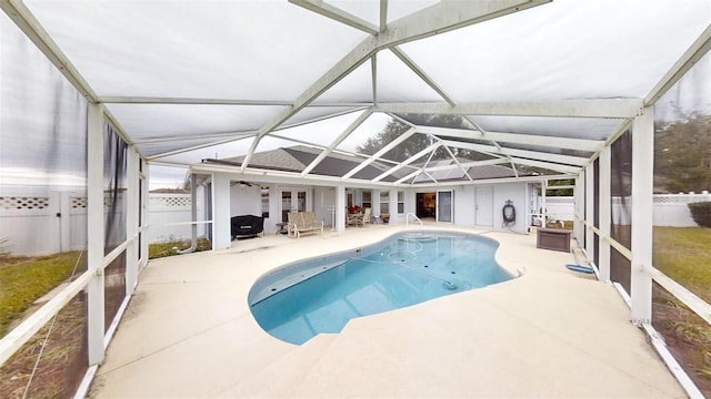 view of swimming pool with a patio and glass enclosure