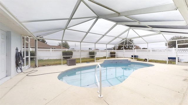 view of pool with a patio area and glass enclosure