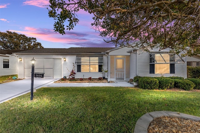 view of front of home with a garage and a lawn