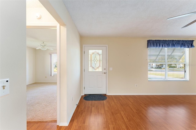 foyer with wood-type flooring, a textured ceiling, and ceiling fan