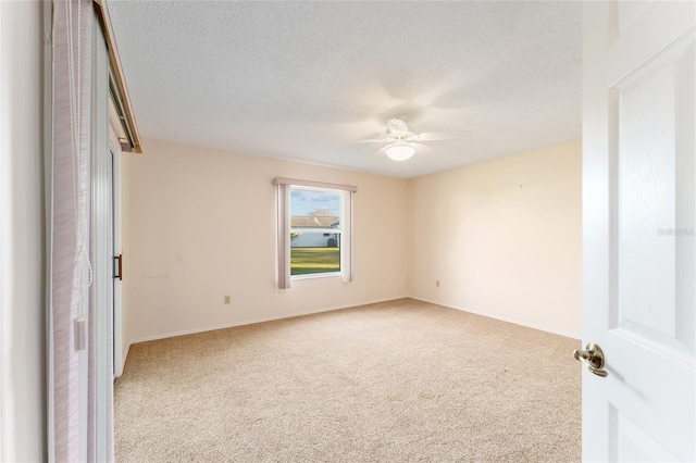 unfurnished room with light carpet, ceiling fan, and a textured ceiling