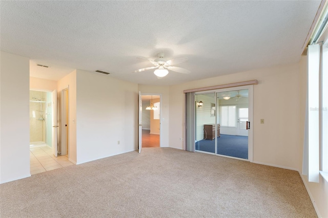 unfurnished bedroom with a textured ceiling, connected bathroom, light colored carpet, and ceiling fan with notable chandelier