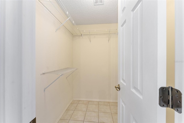 spacious closet with light tile patterned floors