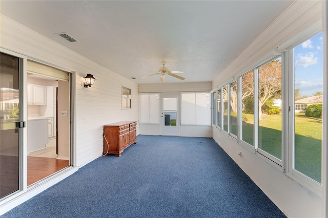 unfurnished sunroom with ceiling fan