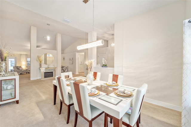 carpeted dining area featuring lofted ceiling