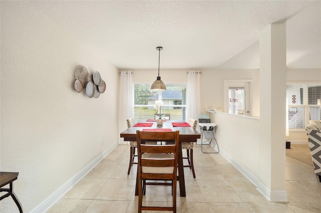 tiled dining room with a textured ceiling