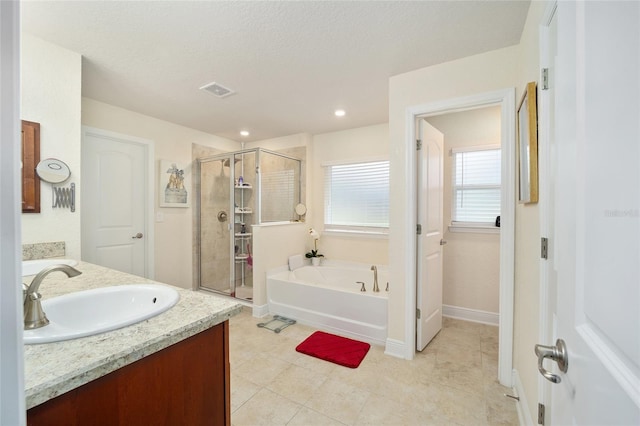 bathroom with shower with separate bathtub, vanity, and a textured ceiling