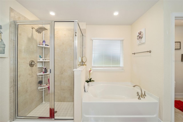 bathroom featuring shower with separate bathtub