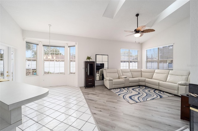 living room with plenty of natural light, light hardwood / wood-style flooring, ceiling fan with notable chandelier, and vaulted ceiling