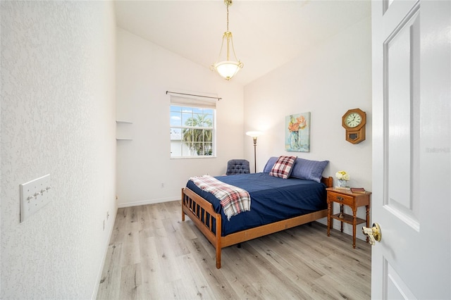 bedroom featuring light wood-type flooring and lofted ceiling