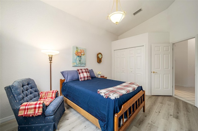 bedroom with a closet, high vaulted ceiling, and hardwood / wood-style flooring